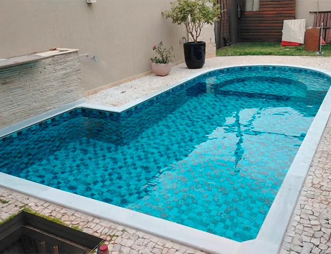 Piscina com borda de pedra e vinil em tons de azul
