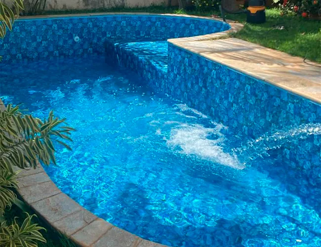 Piscina com hidromassagem e vinil azul em funcionamento