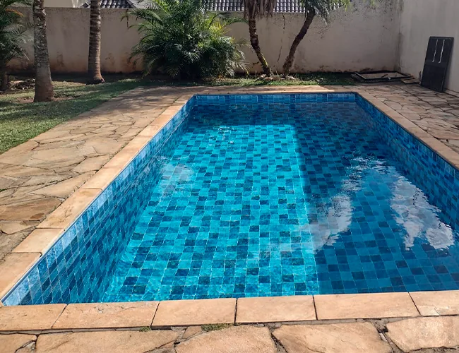 Piscina retangular em jardim com vinil de pastilha azul